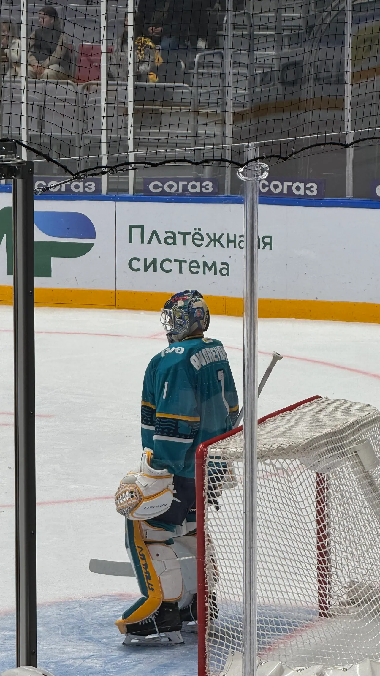 Вратарь «Сочи» в бирюзовой форме у ворот, снятый с трибуны через ограждение